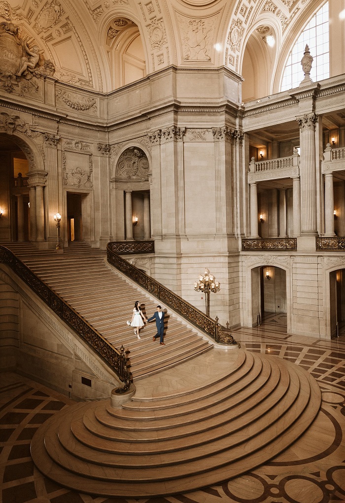 couple walking down stairs in sf city hall